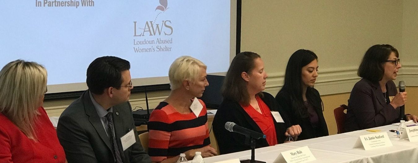 25 – LCWAG Help End Violence Against Women in Loudoun Panel discussion on ending violence against women, featuring several speakers seated at a conference table with microphones.