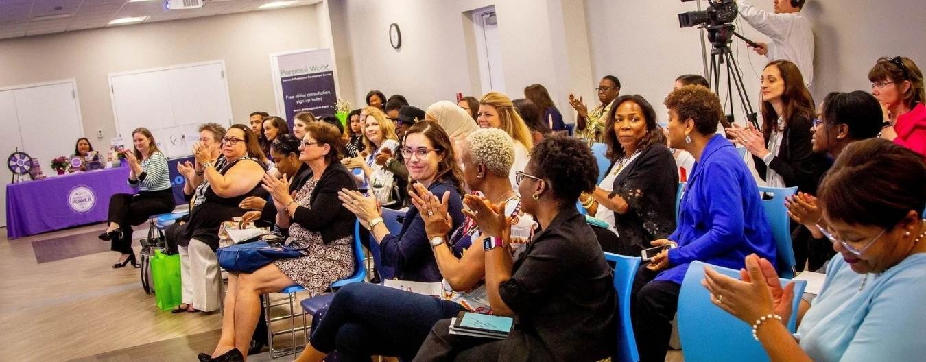 A group of women in the audience clapping their hands in unison.