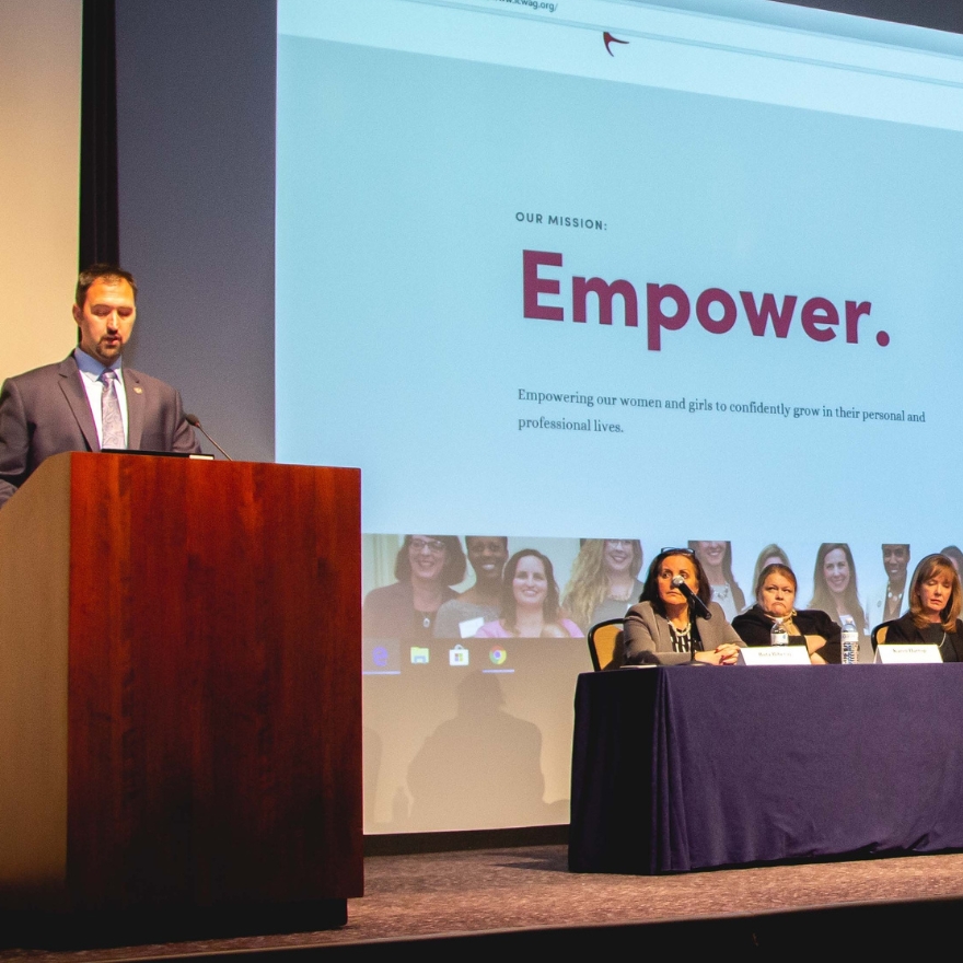Presenter and panel members on stage.